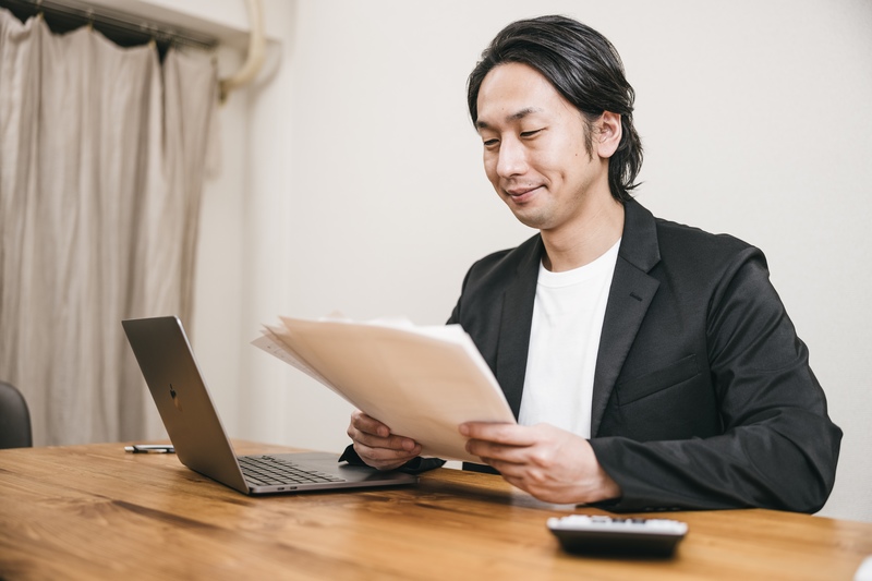 書類をチェックする笑顔の男性